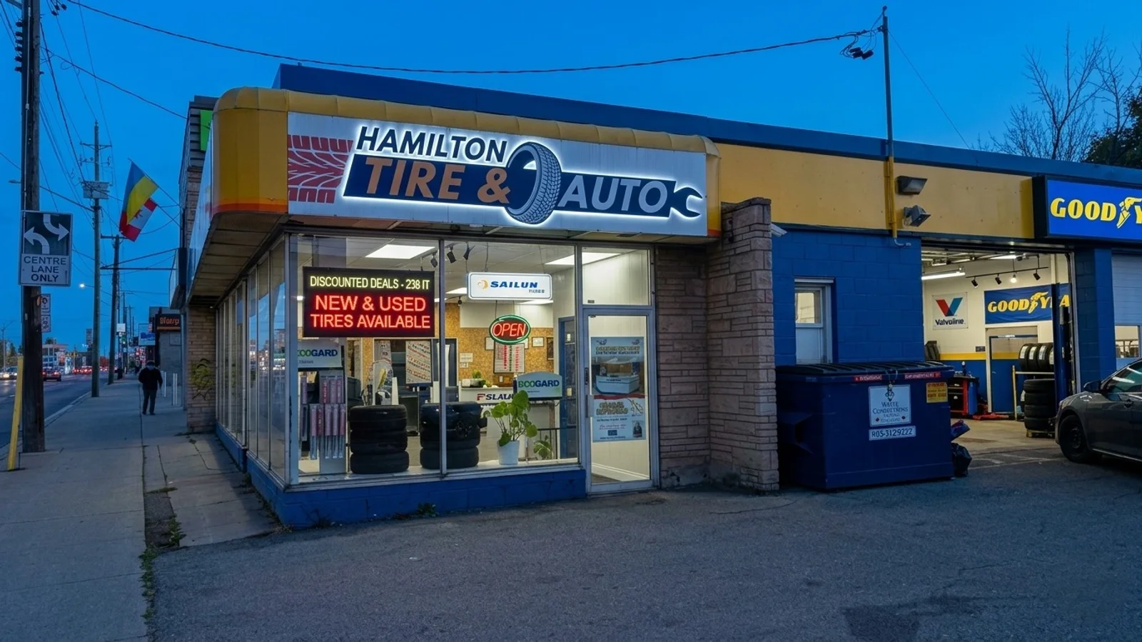 Hamilton Tire & Auto on Barton Street at dusk, the shop lit and open